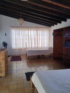 a bedroom with two beds and a large window at Linda casa en Tepoztlan centro 2 in Tepoztlán