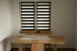 a dining room table with two chairs and a window at Apartman Pavić in Livno