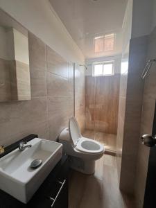 ein Badezimmer mit einer weißen Toilette und einem Waschbecken in der Unterkunft Hotel Paranawa in Baranoa