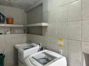 a bathroom with a toilet and a sink at Quarto Privativo Próximo ao Metro e Aeroporto in Sao Paulo