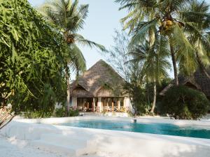 a resort with a swimming pool and palm trees at Bahati Sunset Bungalows Michamvi in Michamvi