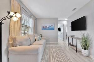 a living room with a couch and a flat screen tv at The Bardmoor a Luxury Family Retreat in St Pete in Seminole