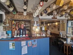 a bar with a man standing at the counter at Woodvale Bungalow in Little Haven