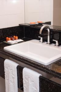 a bathroom counter with a white sink and towels at Sol Ipanema Hotel in Rio de Janeiro