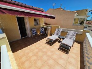 a patio with four chairs and a grill on a house at Cozy Townhouse in San Fulgencio