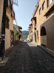 an empty cobblestone street in a town with buildings at Linda Casa en Tepoztlan centro 1 in Tepoztlán +23 photos
