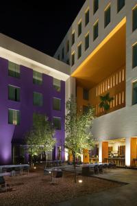 a building with a courtyard with tables and trees at Hilton Garden Inn Monterrey Airport in Monterrey