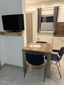 a room with a table and two chairs and a television at Feriendorf Lahnsteiner Höhe in Lahnstein