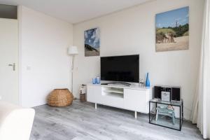 TV a/nebo společenská místnost v ubytování Toplocatie! Strand 300 meter en prachtig uitzicht op de duinen, no additional costs