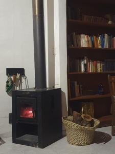 a black stove in a room with a book shelf at Casita con entorno espectacular in La Cumbre