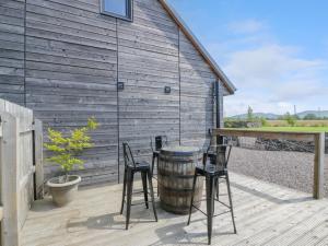 two chairs and a barrel on a wooden deck at Fasgadh in Perth