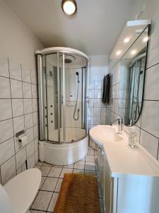 ein Bad mit einer Dusche, 2 Waschbecken und einem WC in der Unterkunft Experience Trshavn's Vibrant Culture in Tórshavn