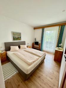 ein Schlafzimmer mit großem Bett und großem Fenster in der Unterkunft Strandhotel Prinz in Ossiach + 35 Fotos
