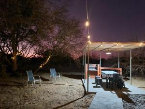 a table and chairs under a tent at night at Domo en el desierto in La Huaica