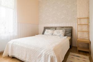 a bedroom with a bed with white sheets and a window at Vintage Four terrassiga korter in Haapsalu