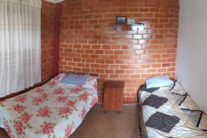 a room with two beds and a brick wall at casa de campo dentro de la ciudad in Chachapoyas