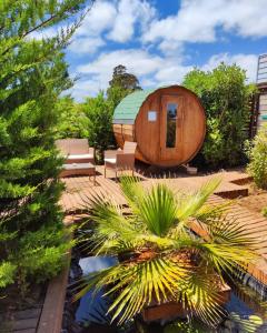 ein rundes Holzhaus mit Teich in einem Garten in der Unterkunft Mini Domos La Tribu Ecolodge in Algarrobo