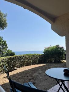 eine Terrasse mit Tisch und Stühlen und dem Meer in der Unterkunft Vista in Roquebrune-sur-Argens + 13 Fotos