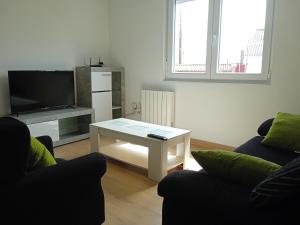 a living room with two couches and a coffee table at Piso Muxía centro in Muxia