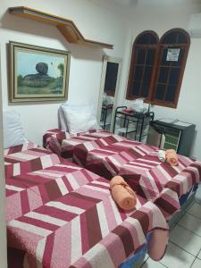two beds sitting next to each other in a room at SUÍTE Alfa in Vila Velha