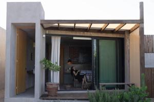 a woman sitting on the porch of a house at Casa Michaus Valle de Guadalupe in Valle de Guadalupe