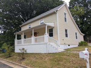 una casa blanca con un porche y un patio en Modern Mill House Walk To Downtown Durham, en Durham
