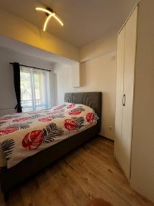 a bedroom with a bed with a floral bedspread at Apartman Dioniz Fojnica in Fojnica