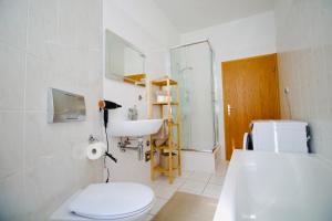 a white bathroom with a toilet and a sink at Apartment Fröhlich am Staatstheater, zentrale Lage, für bis zu 4 Personen, 46qm in Cottbus +21 photos