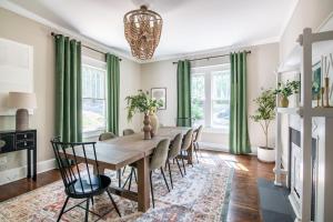 a dining room with green curtains and a wooden table and chairs at Spacious Highland Park Home, Family&pet Friendly in Birmingham