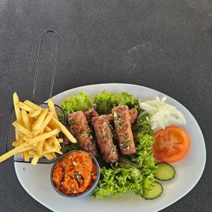 a plate of food with meat and french fries at Hotel Fuchs & Hase SELF CHECK IN in Rosegg