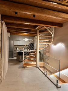 a spiral staircase in a kitchen with wooden ceilings at Techo de piedra in Kastellákia