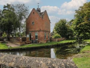 an old brick building next to a river at Daisy in Leominster