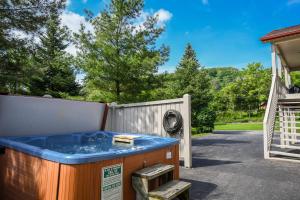 a hot tub in a yard with a fence and trees at Light My Fire in McHenry