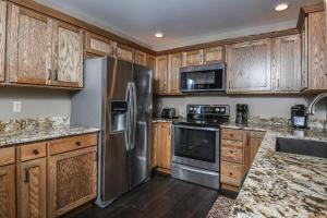 a kitchen with wooden cabinets and stainless steel appliances at Light My Fire in McHenry +47 photos