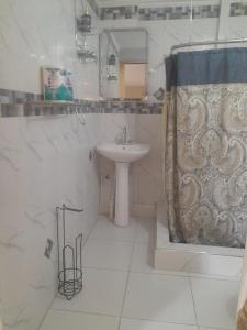 a white bathroom with a sink and a shower at Bobby Vacational Home in Portmore
