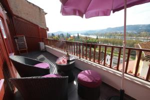 a balcony with tables and chairs and an umbrella at Casas da Alegria in Coimbra