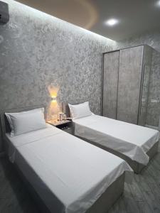 タシュケントにあるTownHouse Near To Tashkent Terminal 3の白い壁の部屋にベッドが2つある