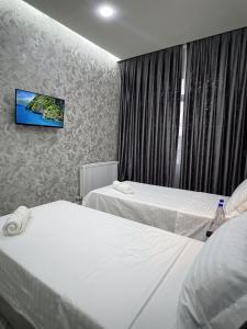 タシュケントにあるTownHouse Near To Tashkent Terminal 3のベッド2台、壁掛けテレビが備わるホテルルームです。 +8枚の写真