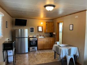 サウス・フォークにあるCozy cabin #4 at Aspen Ridge Cabinsのキッチン(ステンレス製の冷蔵庫、テーブル付)