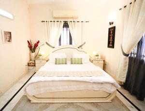a bedroom with a large white bed in a room at Mohalla Rooftop Retreat in Karachi
