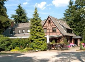 a house with a table and chairs in front of it at Hotel Ferien auf der Heid in Eversen