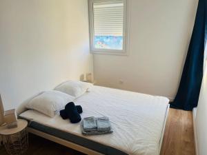un letto con due cuscini e un cappello sopra di Villa T2, île de la marina, climatisée a Cap d'Agde