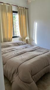 a large bed in a bedroom with a window at La Maga in Santa Rosa de Calamuchita