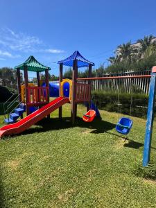 a playground with a slide in the grass at VG FUN Praia do Futuro Pé na Areia ap 311 IMOB TEMPORADA in Fortaleza