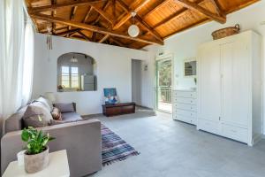 a living room with white walls and a wooden ceiling at Anemoperasma - Peaceful Stay in an Olive Grove in Stafylos