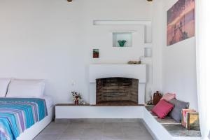 a bedroom with a bed and a fireplace at Anemoperasma - Peaceful Stay in an Olive Grove in Stafylos