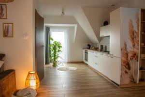 a kitchen with white cabinets and a wooden floor at Stylowe apartamenty in Charzykowy