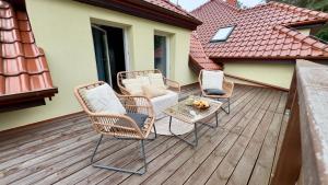 a group of chairs and a table on a deck at Stylowe apartamenty in Charzykowy