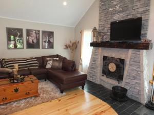 a living room with a couch and a fireplace at La Maison Malabar - Gorgeous Luxury Cabin! in South Haven