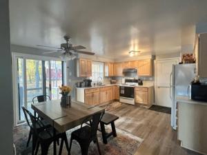 a kitchen with a dining room table and a refrigerator at Lake Therapy - Lakefront, Charming, And Fun! in Mancelona